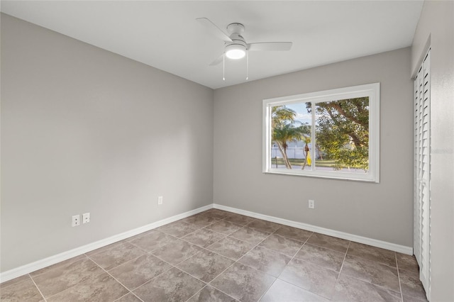 spare room featuring tile patterned floors and ceiling fan