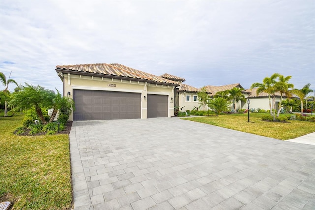 mediterranean / spanish house featuring a front yard and a garage