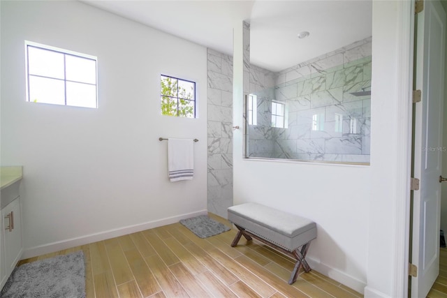 bathroom with walk in shower, vanity, and hardwood / wood-style flooring