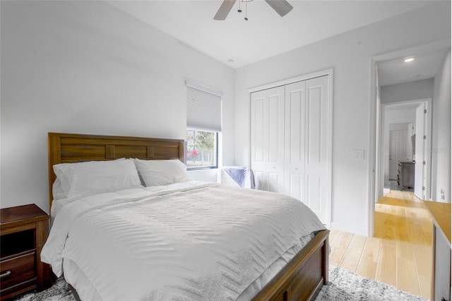 bedroom with ceiling fan, a closet, and light hardwood / wood-style floors