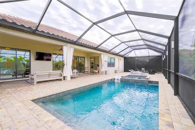 view of swimming pool featuring ceiling fan, outdoor lounge area, an in ground hot tub, a lanai, and a patio