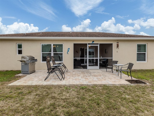 back of property featuring a patio area and a lawn