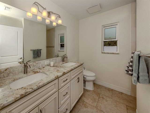 bathroom featuring toilet, vanity, and tile patterned flooring