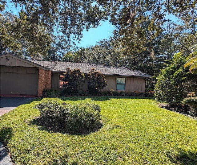 single story home featuring a front lawn and a garage