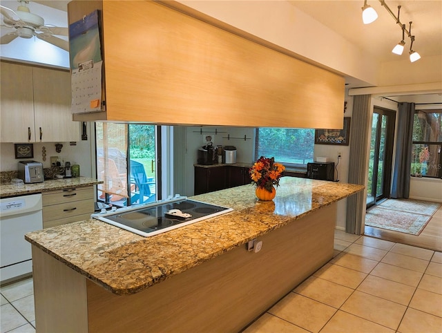 kitchen featuring dishwasher, light stone countertops, light tile patterned floors, and electric stovetop