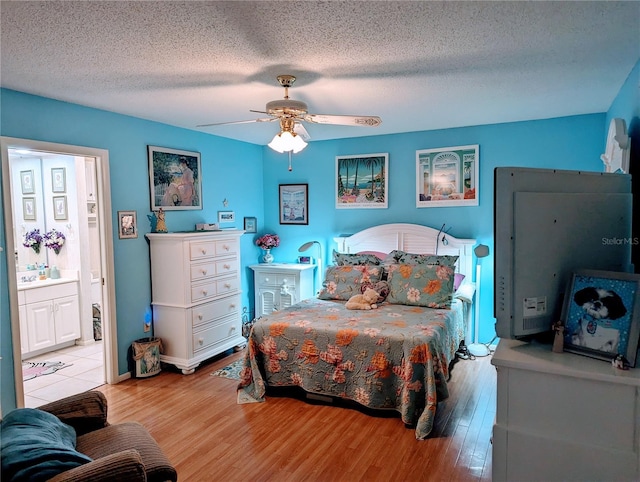 bedroom featuring ceiling fan, light hardwood / wood-style floors, and a textured ceiling