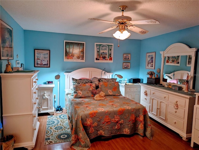 bedroom with ceiling fan, a textured ceiling, and hardwood / wood-style flooring