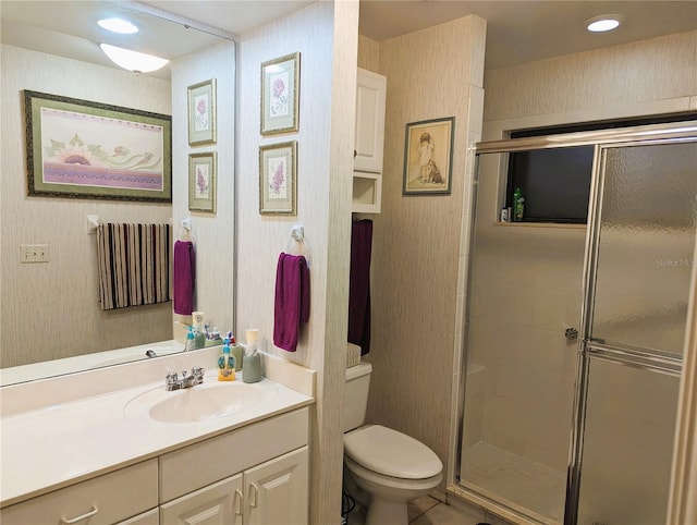 bathroom featuring vanity, toilet, and a shower with shower door