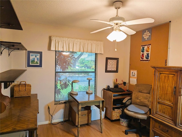 office featuring ceiling fan, light hardwood / wood-style floors, and a textured ceiling