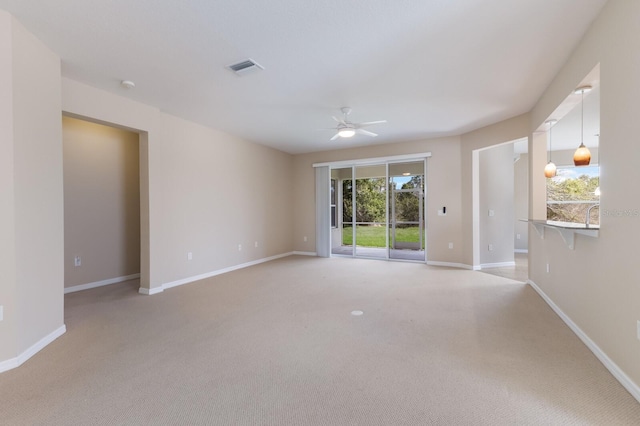 unfurnished room featuring visible vents, ceiling fan, light carpet, and baseboards