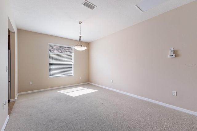 empty room with visible vents, light carpet, and baseboards