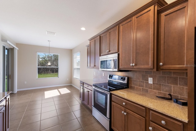 kitchen featuring dark tile patterned floors, visible vents, baseboards, appliances with stainless steel finishes, and backsplash