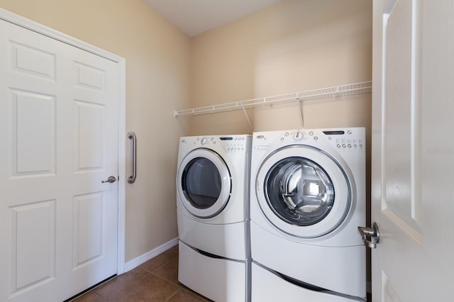 clothes washing area with laundry area, dark tile patterned floors, baseboards, and independent washer and dryer