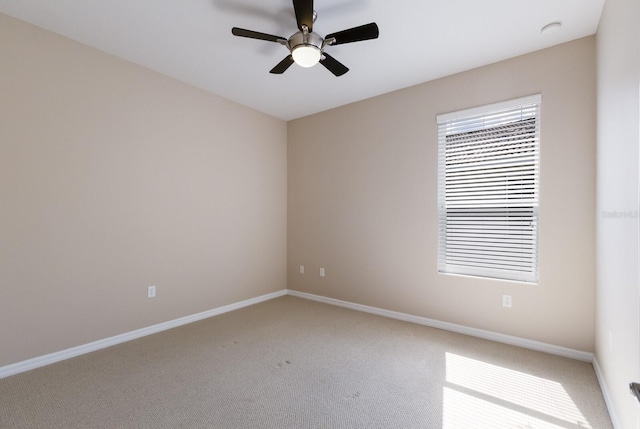 unfurnished room featuring a ceiling fan, light colored carpet, and baseboards