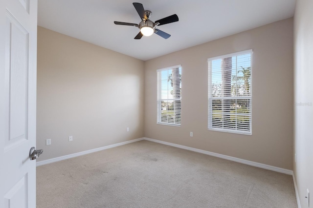 empty room with a ceiling fan, baseboards, and carpet flooring