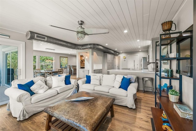 living room with ceiling fan, light wood-type flooring, and wood ceiling