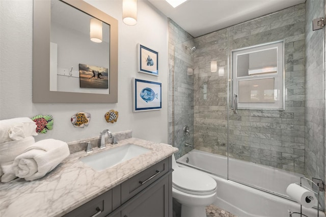 full bathroom featuring toilet, vanity, and shower / bath combination with glass door