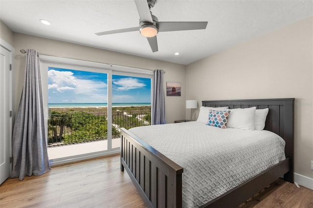 bedroom featuring ceiling fan, light hardwood / wood-style flooring, access to outside, and multiple windows