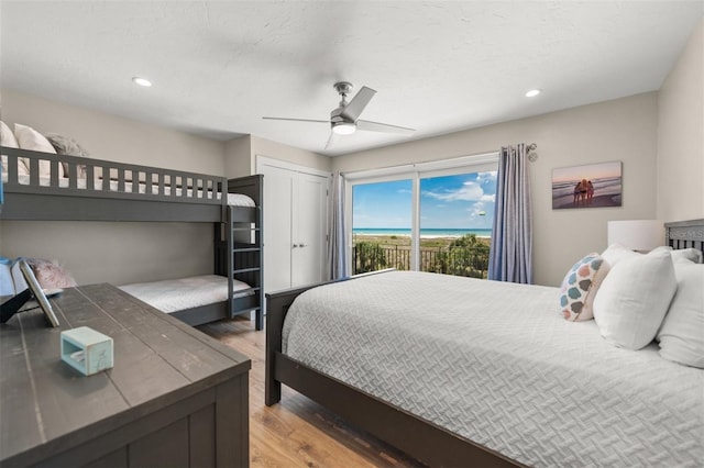 bedroom featuring a textured ceiling, ceiling fan, hardwood / wood-style floors, and access to outside