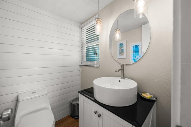 bathroom featuring hardwood / wood-style flooring, toilet, and vanity