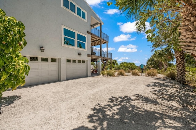 view of side of home featuring a garage and a balcony