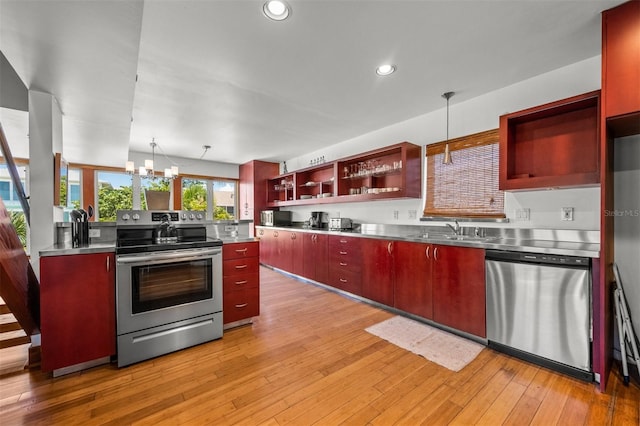 kitchen with stainless steel counters, decorative light fixtures, appliances with stainless steel finishes, and sink