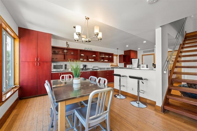 dining space with a chandelier and light wood-type flooring