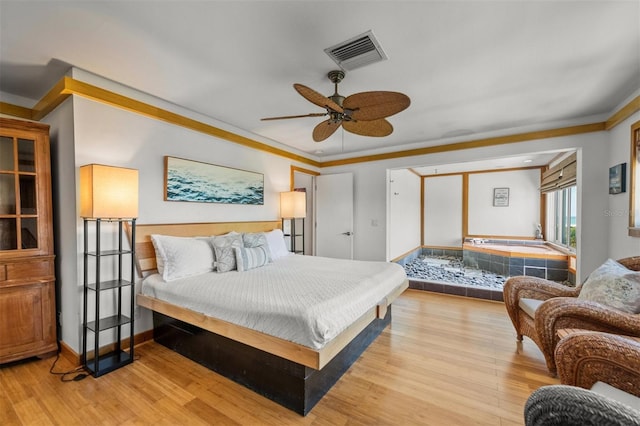 bedroom with ceiling fan, crown molding, and light hardwood / wood-style flooring