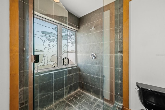 bathroom with toilet and a tile shower