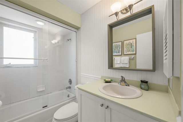 full bathroom featuring toilet, vanity, and shower / bath combination with glass door