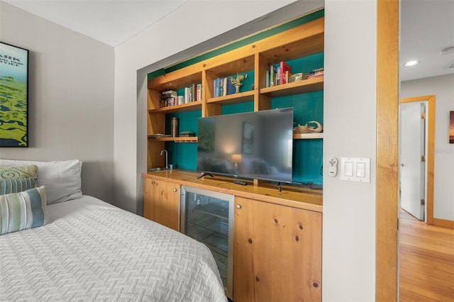 bedroom featuring wet bar, hardwood / wood-style floors, and beverage cooler