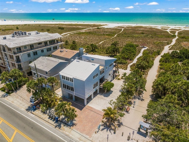 birds eye view of property with a water view and a beach view