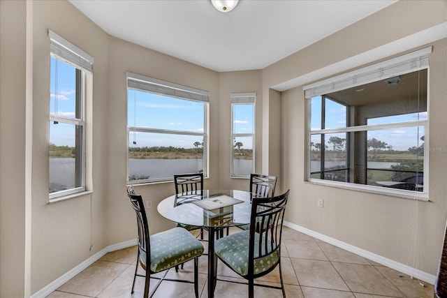 tiled dining area featuring a water view