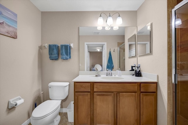 bathroom featuring toilet, tile patterned flooring, a shower with door, and vanity