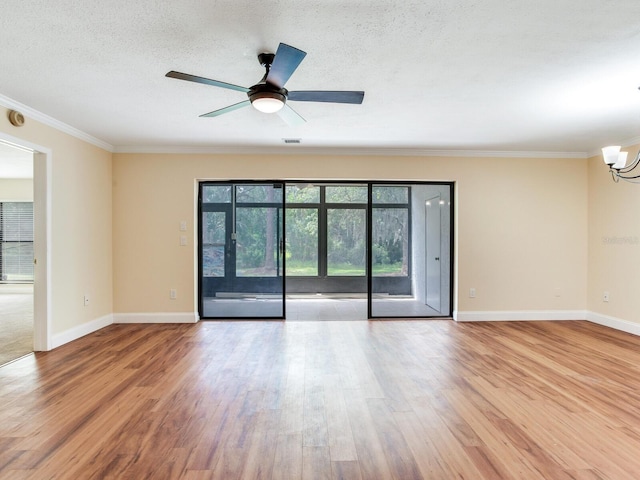 spare room with a textured ceiling, ceiling fan with notable chandelier, light hardwood / wood-style flooring, and ornamental molding