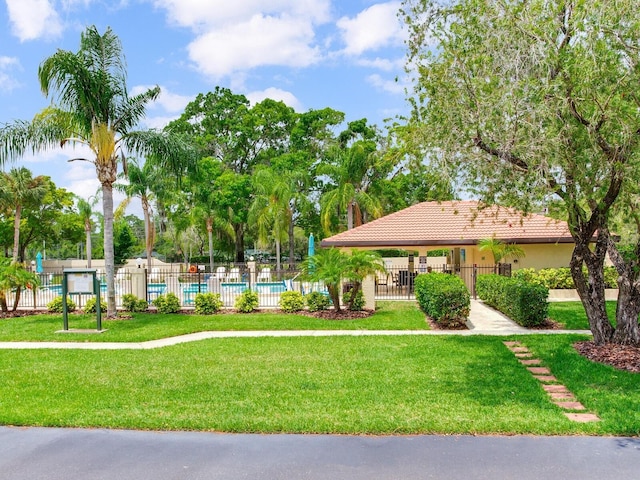 view of property's community with a lawn and a swimming pool