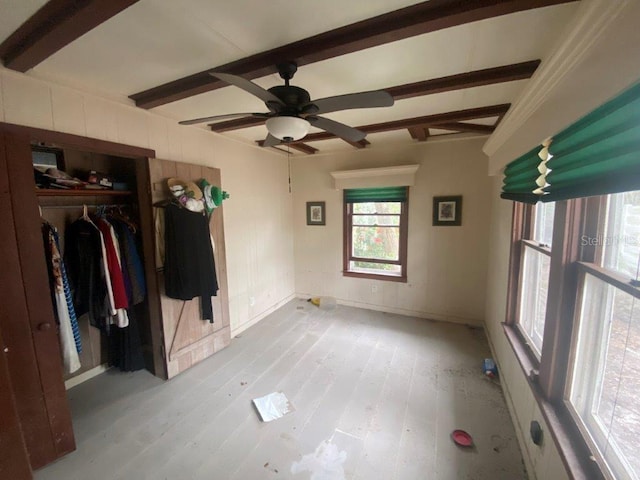 interior space featuring beam ceiling, light wood-type flooring, and ceiling fan