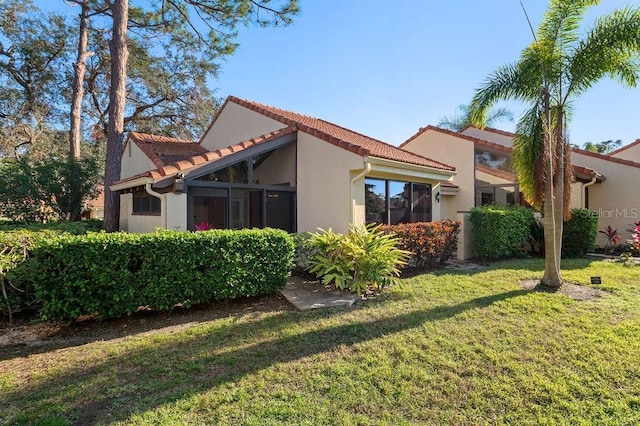 view of property exterior featuring a yard, a tiled roof, and stucco siding