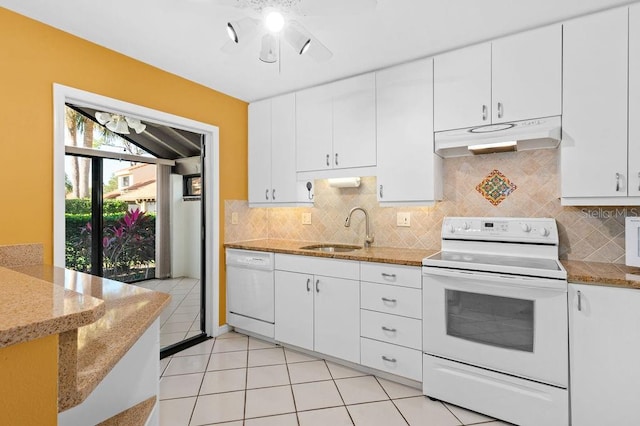 kitchen with white appliances, white cabinets, a sink, and under cabinet range hood