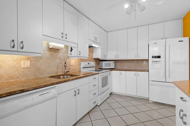 kitchen with white cabinetry, a sink, dark stone counters, white appliances, and under cabinet range hood