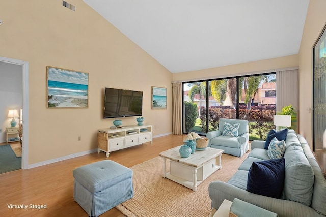 living room with light wood-type flooring, visible vents, high vaulted ceiling, and baseboards