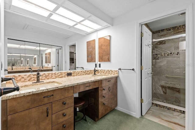 full bath featuring a shower stall, baseboards, backsplash, and vanity