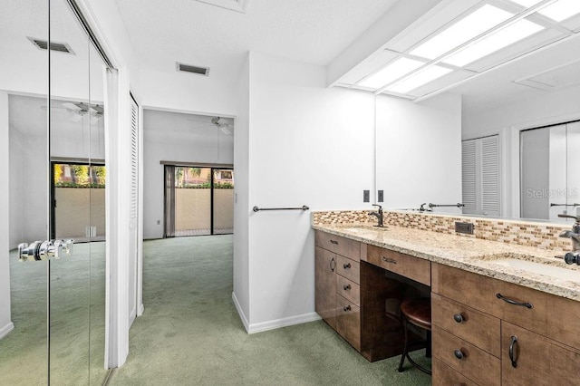 bathroom with tasteful backsplash, visible vents, a sink, and double vanity