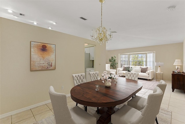 dining space with light tile patterned floors and an inviting chandelier