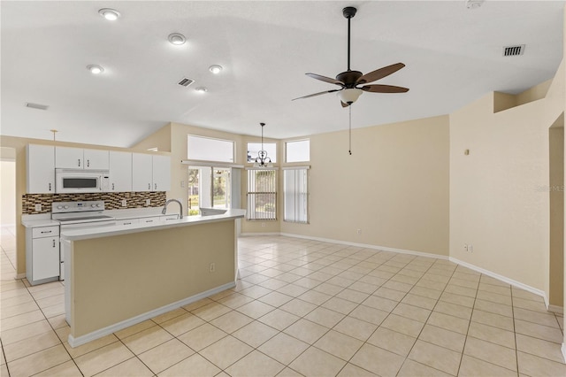 kitchen featuring white appliances, a kitchen island with sink, white cabinets, ceiling fan with notable chandelier, and tasteful backsplash