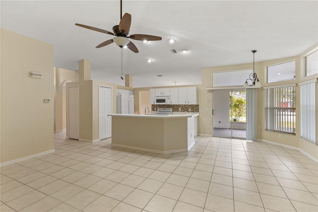 kitchen with decorative backsplash, white appliances, ceiling fan with notable chandelier, decorative light fixtures, and white cabinets