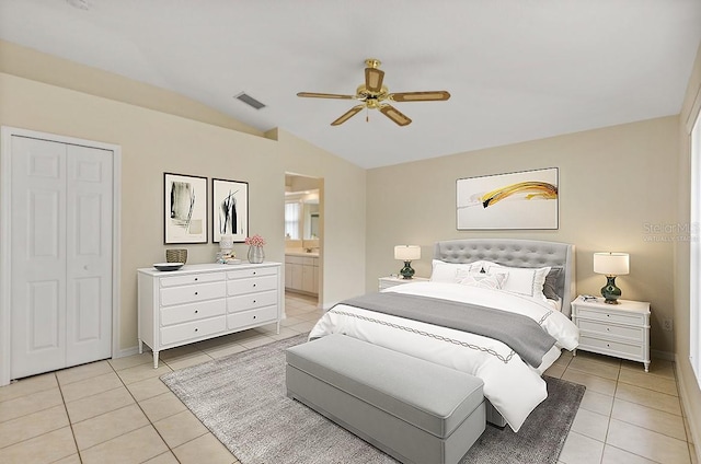 bedroom featuring ceiling fan, a closet, light tile patterned floors, and lofted ceiling