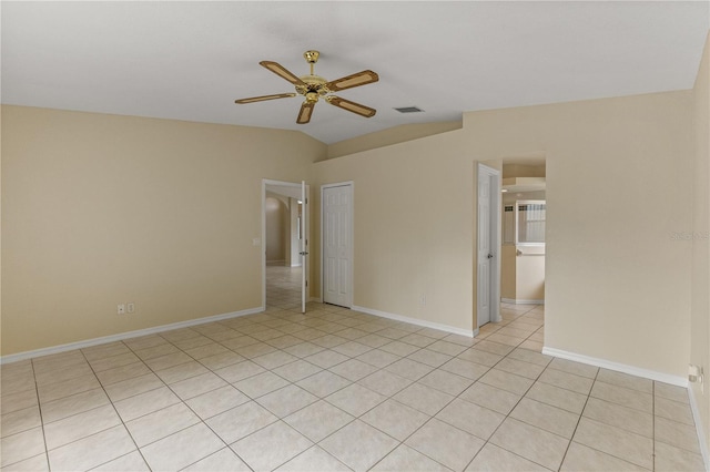 tiled empty room with ceiling fan and vaulted ceiling