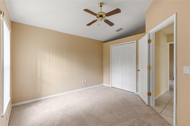 unfurnished bedroom featuring a closet, ceiling fan, and light colored carpet