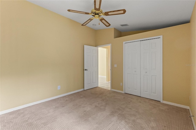 unfurnished bedroom with light carpet, a closet, vaulted ceiling, and ceiling fan